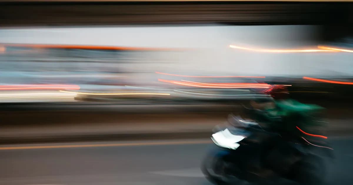 Dynamic image capturing the speed and motion of a motorbike in a city setting