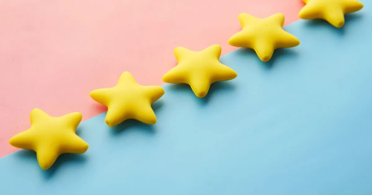 Yellow stars on pink and blue pastel background for rating or review concept