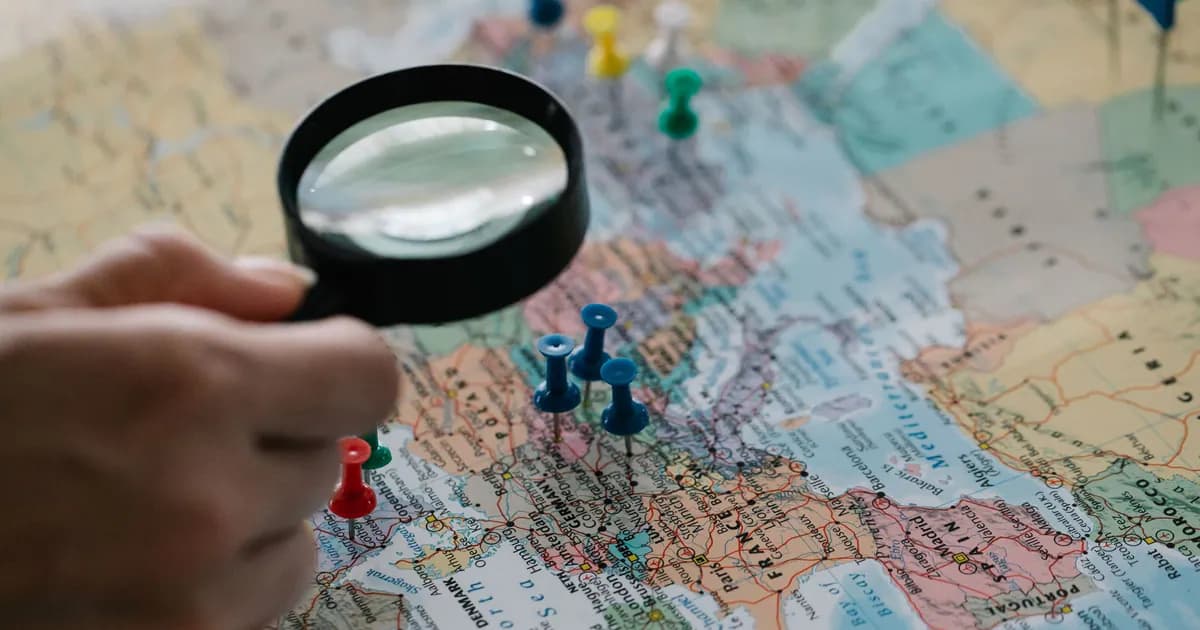 Magnifying glass focuses on pins highlighting travel destinations on a world map