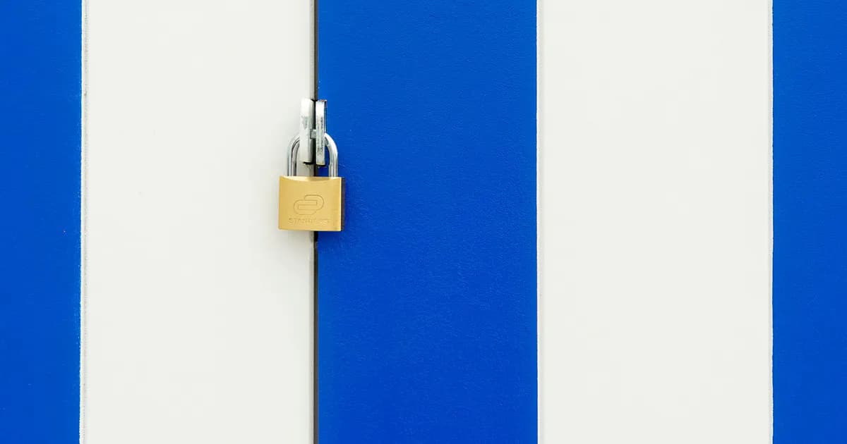 Padlock securing a blue and white striped door