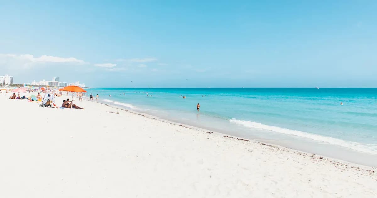 A vibrant Miami Beach scene with clear skies, blue ocean, and white sand