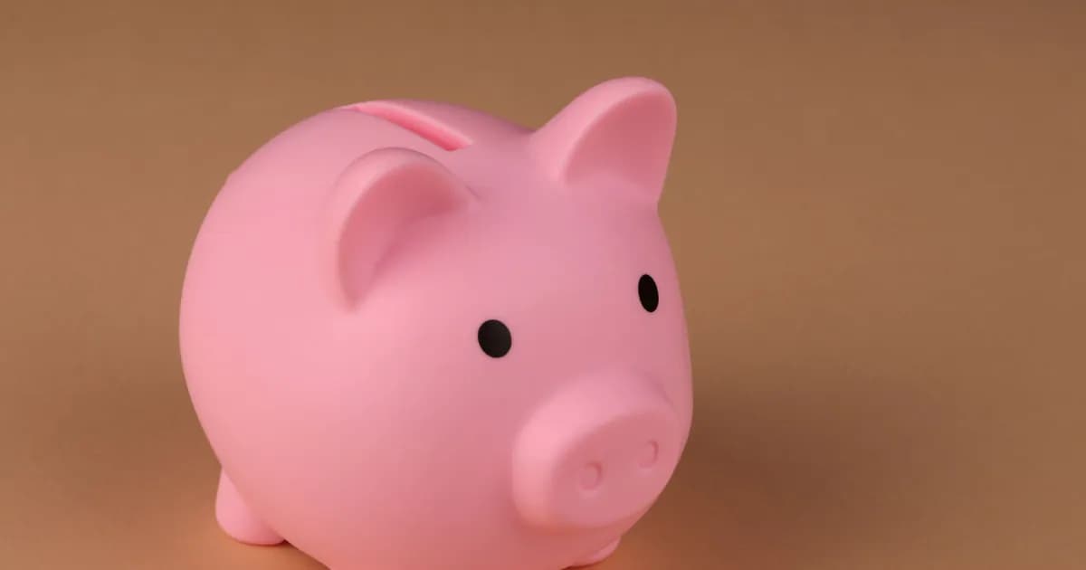A pink piggy bank symbolizes savings and budgeting on a simple brown backdrop
