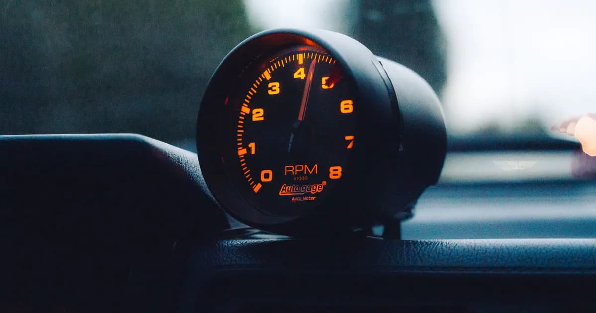 A glowing RPM gauge mounted on a car dashboard